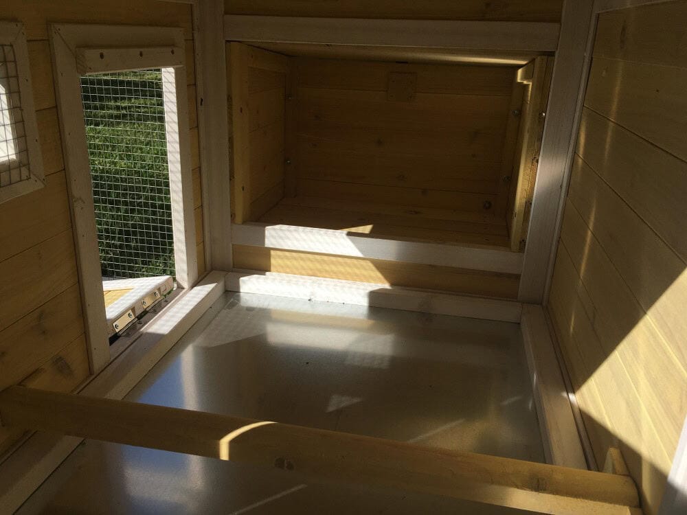 An inside view of the enclosed house section of a yellow timber rabbit hutch.