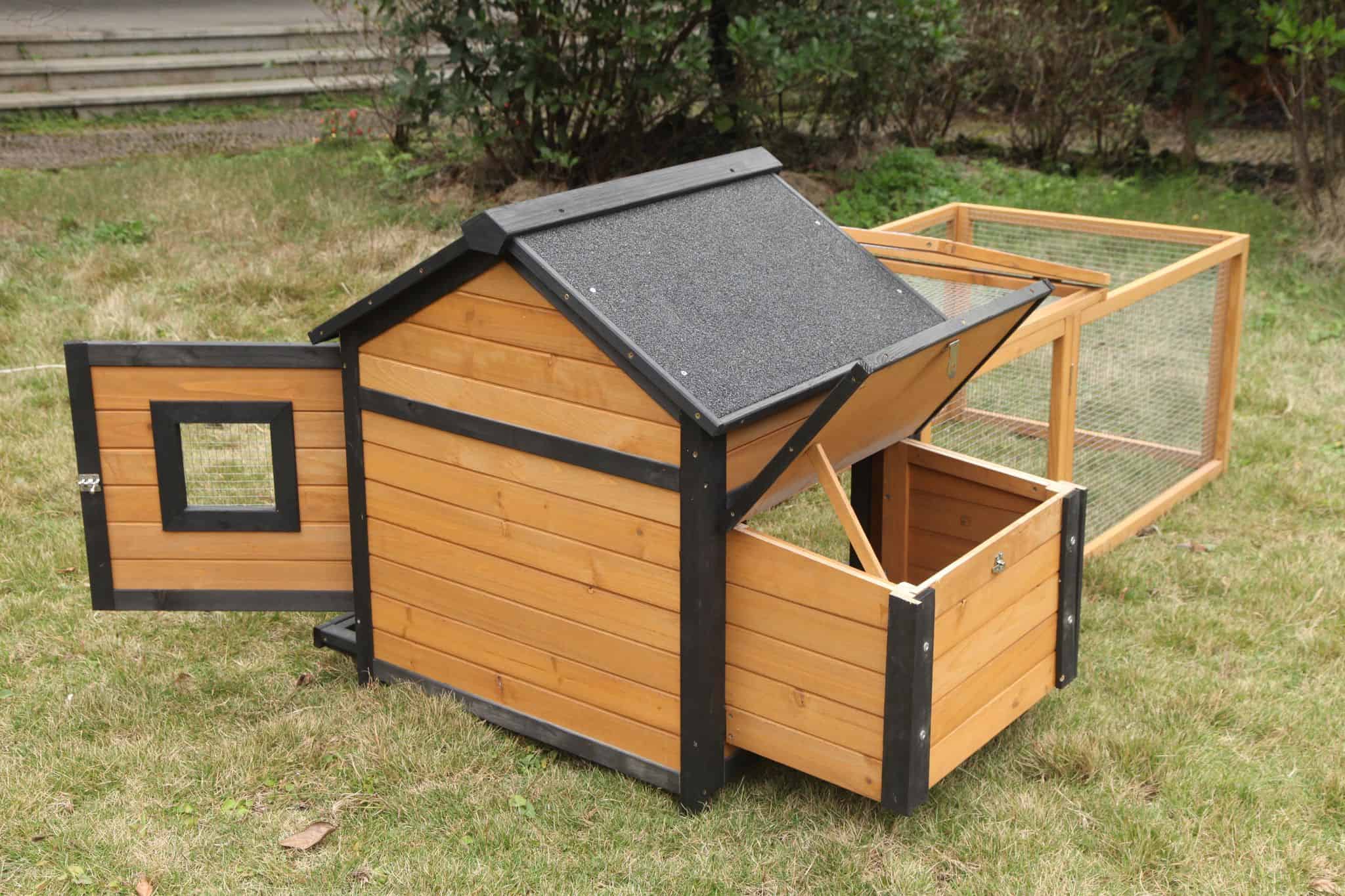 The back view of a brown timber rabbit hutch, showing the access doors open.